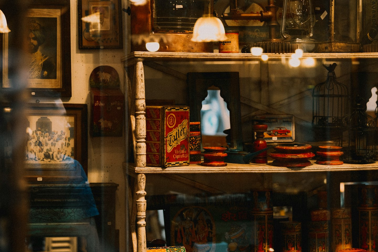 Vintage display case filled with antiques and framed portraits.